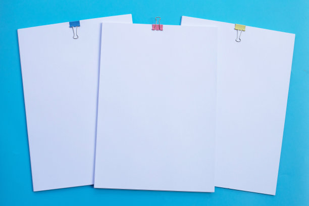 白色纸夹蓝色背景。图片下载