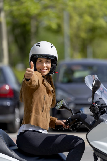 戴安全帽的妇女骑摩托车的ok手势图片下载