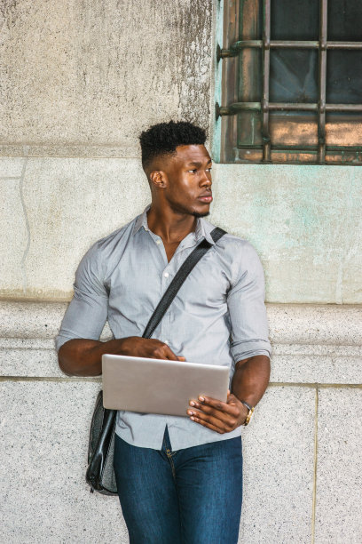 年轻的黑人男子站在纽约街头，用笔记本电脑工作图片下载