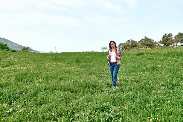快乐美丽，无忧无虑的女人走在绿色的草地上。户外远足，与自然合一。图片下载