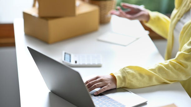 裁剪的照片女性创业企业家与笔记本电脑在互联网上检查订单。图片下载