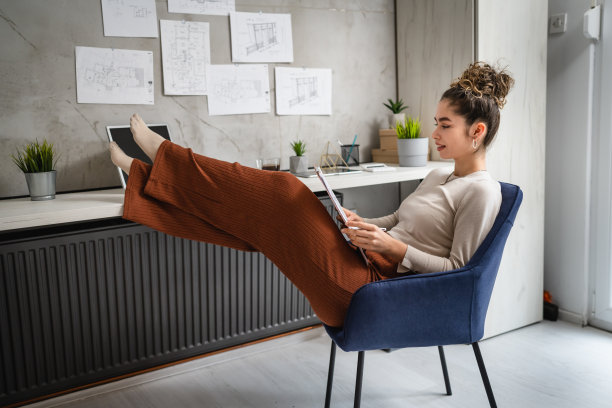 一名年轻的白人女性坐在办公桌前工作，在办公室研究文件放松，而持有夹图表与文件真人复制空间女性工程师或学生计划项目图片下载