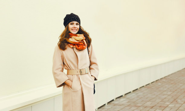 美丽的年轻女子的肖像穿着大衣和围巾在城市图片下载