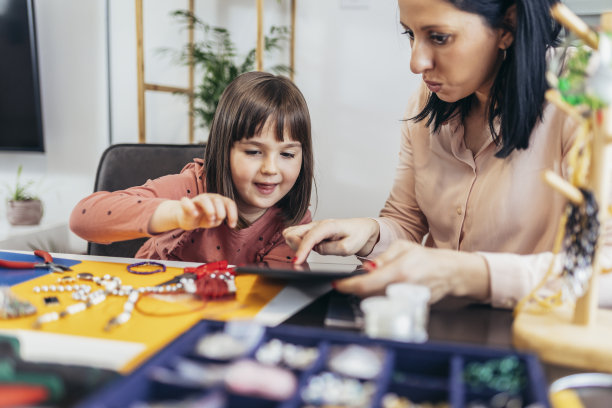 母亲和女儿在家里一起制作手镯很有趣图片下载