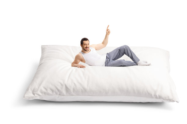 穿着睡衣的年轻人躺在一个大枕头上，指着上面图片下载