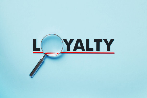 放大镜形成忠诚字在蓝色背景图片下载