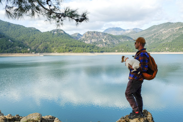 旅行者和他的狗在美丽的目的地。图片下载