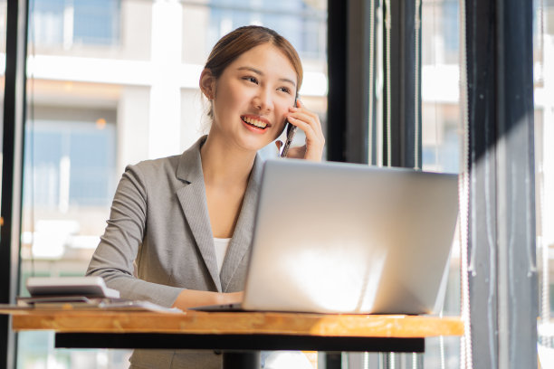 亚洲女性，个体户，专注于带笔记本电脑的手机。财务分析，图表，账目，图表，在线营销计划，基于户外咖啡店的工作理念。图片下载