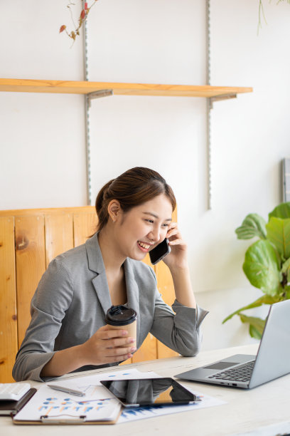 亚洲女性，个体户，专注于带笔记本电脑的手机。财务分析，图表，账目，图表，在线营销计划，基于户外咖啡店的工作理念。图片下载