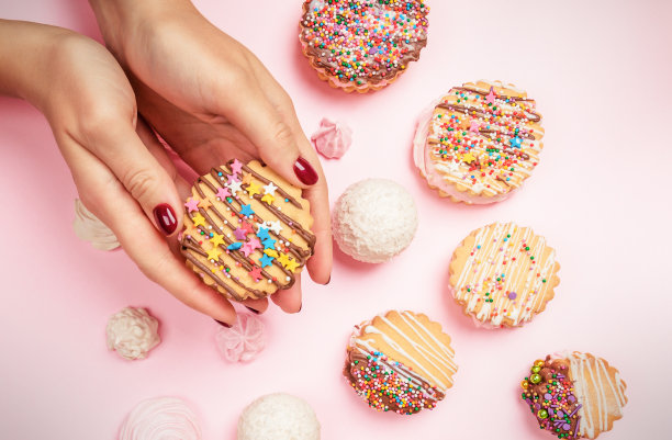 糕点师的女孩手里拿着饼干和三明治。图片下载