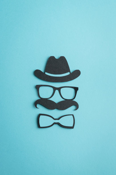 剪纸人物在蓝色的背景。父亲节的概念。男人的一天。垂直的照片。图片下载