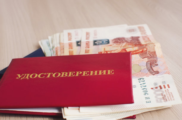 一张红色封面的俄罗斯身份证和一捆俄罗斯钱放在桌子上，特写。滥用职权、受贿的概念。特写,有选择性的重点。图片下载