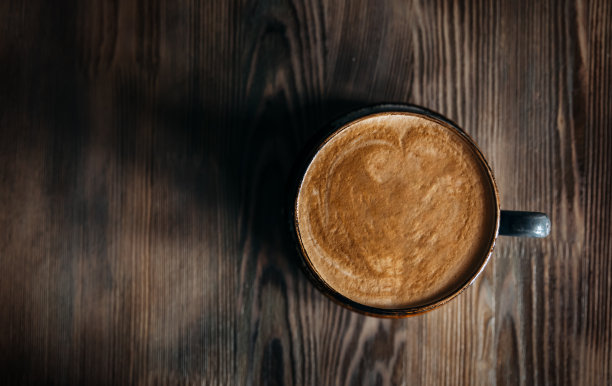 木桌上有一杯咖啡。图片下载