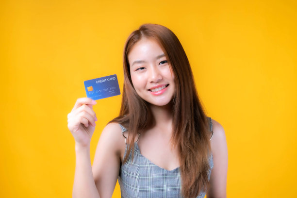 亚洲女孩展示信用卡支付网上购物和-信用卡支付孤立在黄色-网上购物电子商务电话营销的概念图片下载