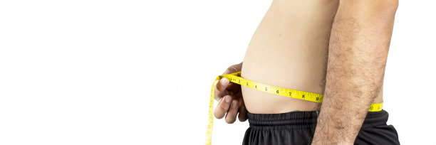 一个胖乎乎的亚洲男人用黄色卷尺量腰围图片下载