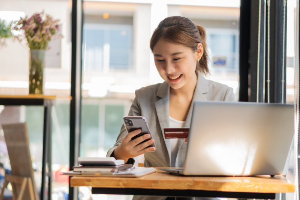 年轻的亚洲女商人使用信用卡，在笔记本电脑、零售商店、电子商务、智能手机、智能支付交易、转账技术上进行金融支付和网上购物。图片下载