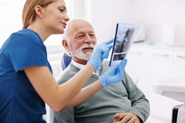 牙科医生和病人看颚x光片图片下载