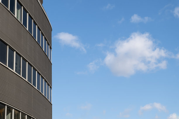 在一个阳光明媚的夏天，这座城市的现代办公楼的立面图片下载