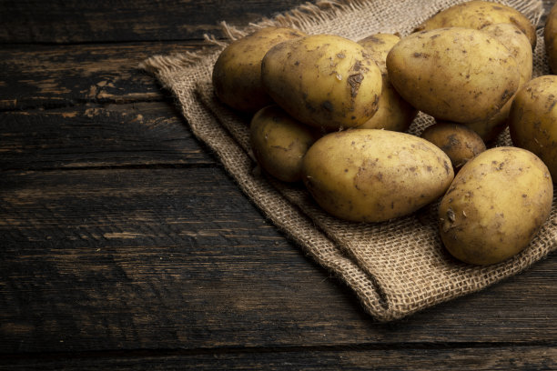 黑色背景上的新鲜有机土豆图片下载