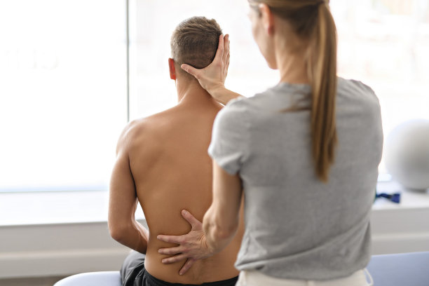 现代康复理疗女性工作者与男性客户背部治疗图片下载
