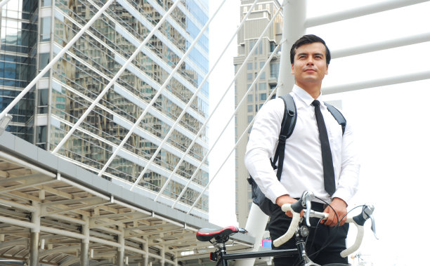 在首都的步行街上骑自行车的商人工人。图片下载