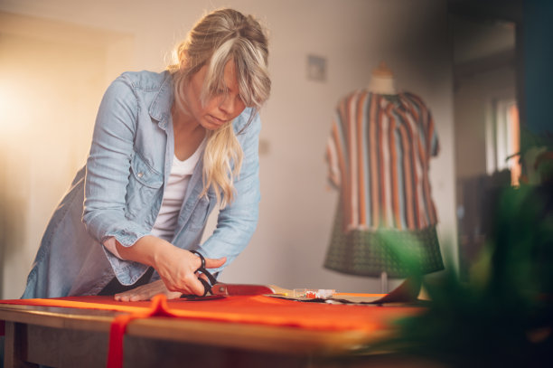 女裁缝在家工作，剪裁漂亮的衣服图片下载