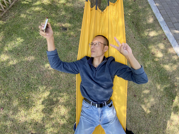 吊床上的男人用手机自拍图片下载