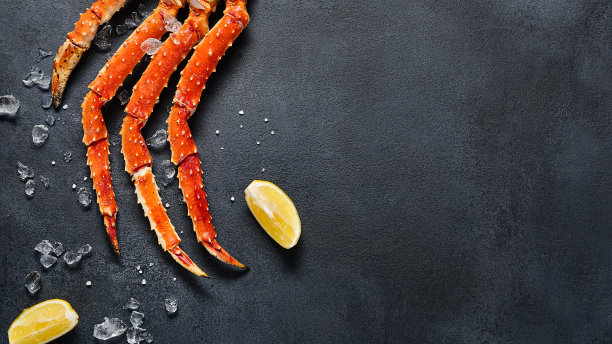 深色背景下的蟹腿顶视图。黑色石板桌上的美味蟹海鲜。甲壳类海鲜美学。豪华蟹肉美食平面图。阿拉斯加蟹腿海鲜菜单背景。图片下载