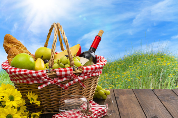 草地上装满食物和酒的野餐篮图片下载