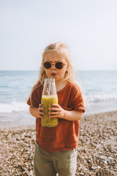 小女孩喝猕猴桃冰沙玻璃瓶儿童营养健康的生活方式素食夏季家庭度假图片下载