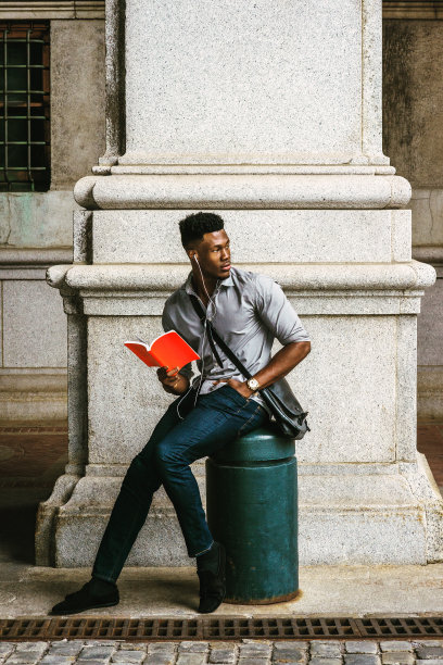 年轻的黑人男子在纽约街头读红色的书图片下载
