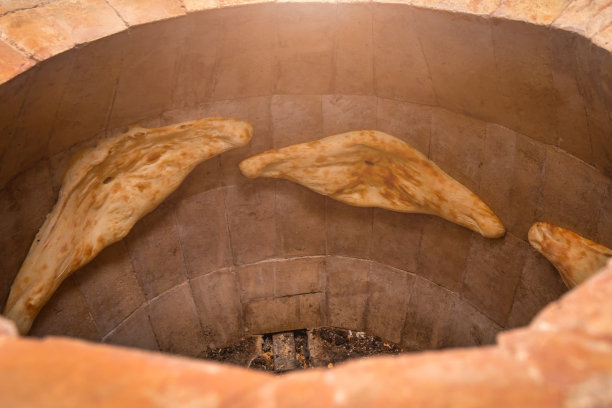 格鲁吉亚Shoti面包在一个传统的砖炉里烤的特写。照片与照明图片下载