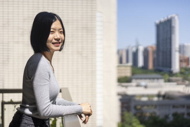 一位亚洲妇女在家里的阳台上望着远方图片下载