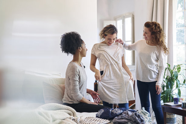 女人站在卧室里给女性朋友送衣服图片下载