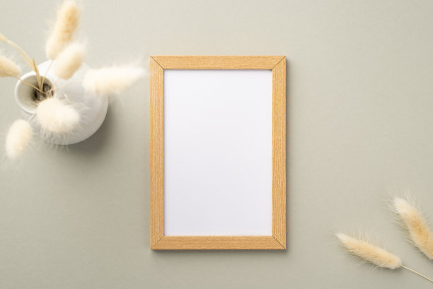 顶视图照片的木制相框和陶瓷花瓶白色lagurus花在粉彩灰色背景与空白空间图片下载
