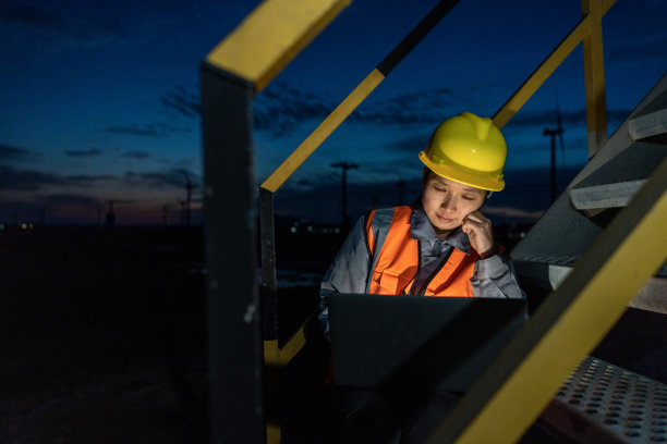 一位亚洲女工程师正坐在电脑前思考如何消除风力发电的问题图片下载