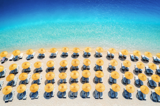 蔚蓝色的大海、空旷的沙滩、夏日日出时的太阳床和遮阳伞。土耳其Oludeniz的蓝色泻湖。热带景观，绿松石水，躺椅。旅行。俯视图图片下载