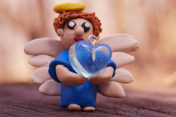 橡皮泥做的玩具天使，手里拿着一颗心。图片下载