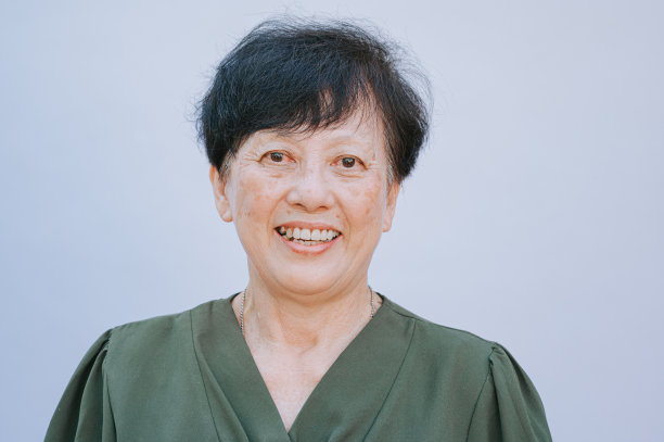 肖像亚洲中国年老妇女看相机与白色背景露齿微笑图片下载