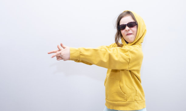 表情和手势。一个戴墨镜的女孩微笑着用手势示意方向。一个六岁白人女孩的肖像，复印的空间。图片下载