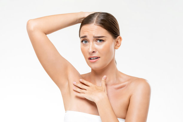 尴尬的白人妇女在毛巾与尴尬的脸显示腋窝在光工作室的白色孤立的背景图片下载