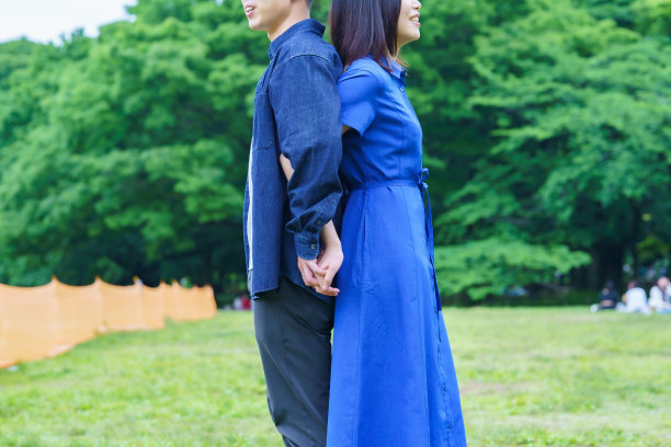 一对背靠背站着的年轻夫妇图片下载