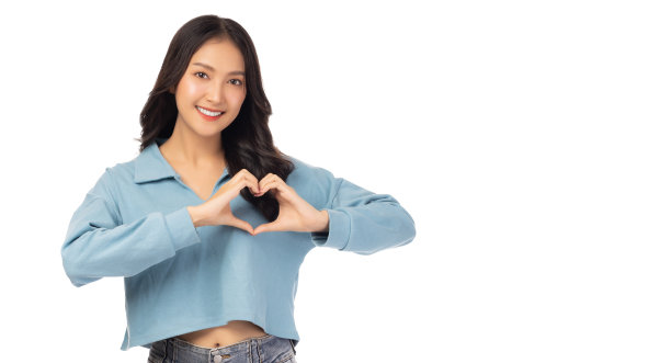 美丽的亚洲女人心形的手势微笑的亚洲女孩穿着休闲的衣服浪漫的年轻女孩做一个心的手势与她的手指孤立在白色情人节的概念图片下载