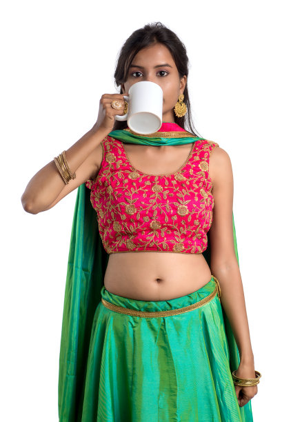 美丽的年轻女孩与一杯茶或咖啡摆在白色的背景图片下载