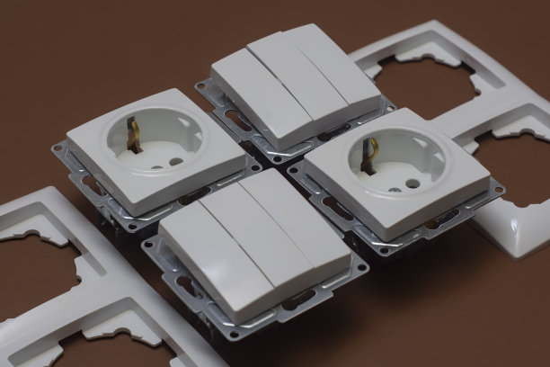 棕色背景上的家用塑料插座和开关图片下载