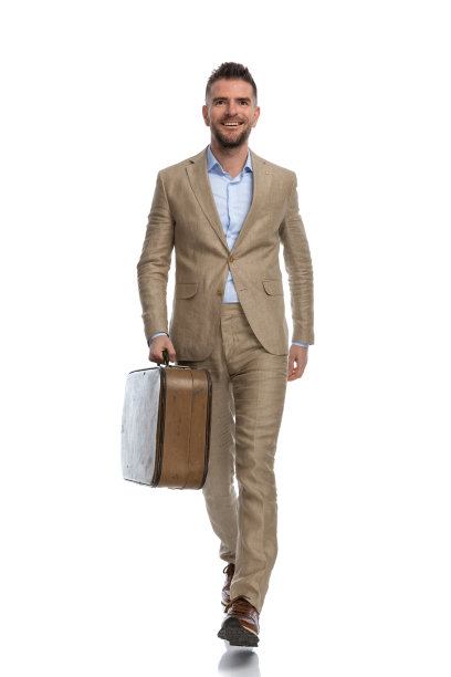 快乐的商人穿着西装，带着行李离开小镇去度假图片下载