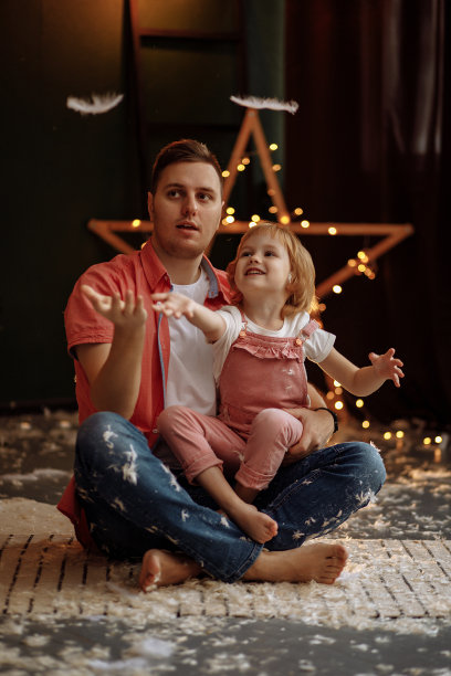 女孩穿着粉红色的衣服，爸爸在玩羽毛图片下载