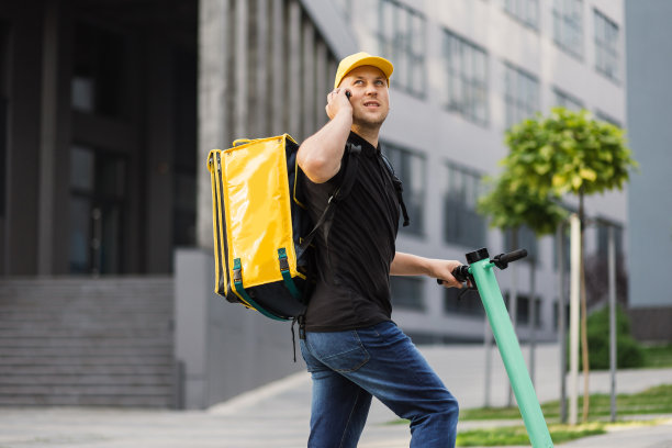 背着黄色背包的白人送餐员。图片下载