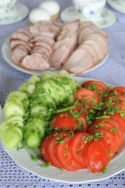 波兰复活节早餐，优雅的餐具和陶器，手绘的蔬菜盘(西红柿和黄瓜)和冷肉盘(香肠，火腿)图片下载