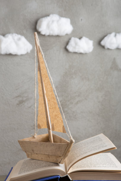 教育是一种旅程的概念，玩具船和书籍就像海浪在木桌上，灵感来源于写一个童话图片下载